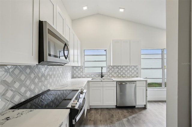 kitchen featuring dark hardwood / wood-style flooring, white cabinets, vaulted ceiling, and appliances with stainless steel finishes