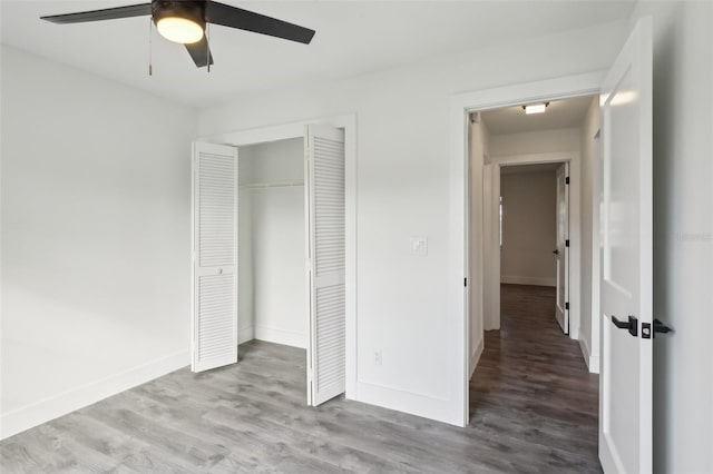 unfurnished bedroom with ceiling fan, light wood-type flooring, and a closet