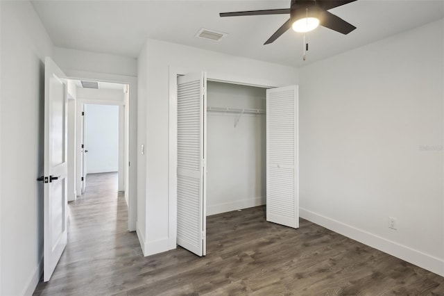 unfurnished bedroom featuring ceiling fan, a closet, and dark wood-type flooring