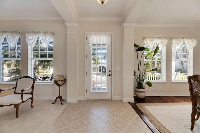 doorway to outside featuring tile patterned floors, plenty of natural light, ornamental molding, and ornate columns