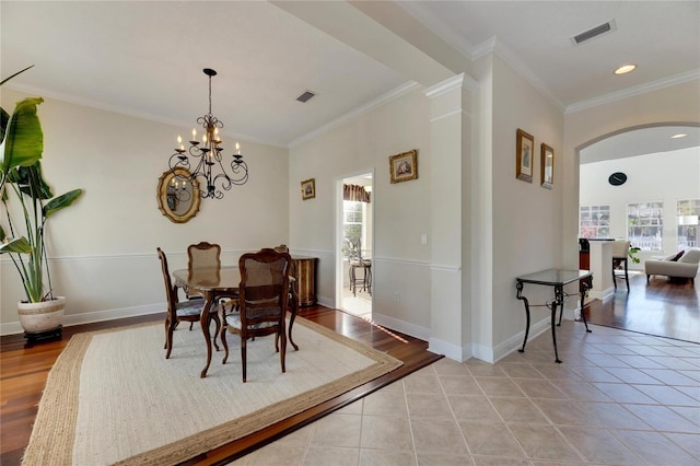 dining area with ornate columns, crown molding, light tile patterned floors, and a chandelier