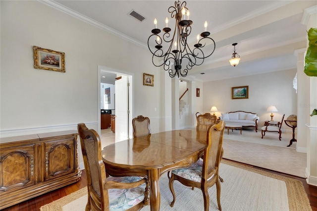 dining room featuring hardwood / wood-style floors, ornamental molding, and a chandelier