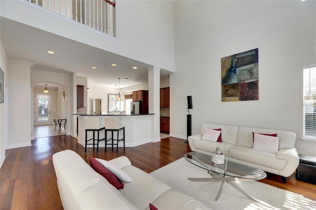 living room featuring dark hardwood / wood-style floors and a towering ceiling