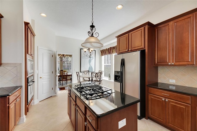 kitchen featuring tasteful backsplash, a center island, pendant lighting, and appliances with stainless steel finishes