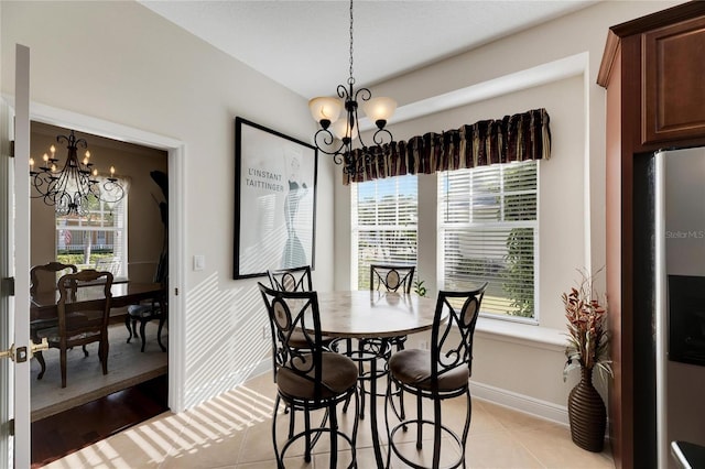 tiled dining room featuring an inviting chandelier