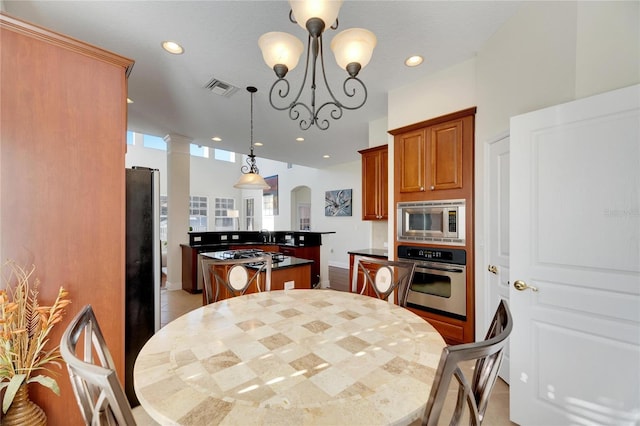 dining area with decorative columns and an inviting chandelier