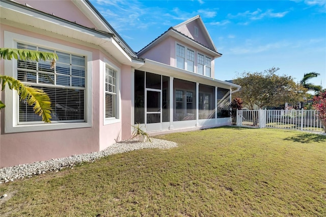 rear view of house with a sunroom and a yard