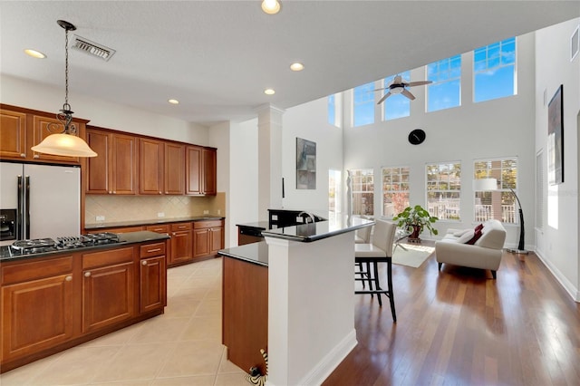 620 Mirabay Blvd, Apollo Beach, FL 33572 - kitchen with dark countertops, ceiling fan, open floor plan, brown cabinetry, and decorative backsplash