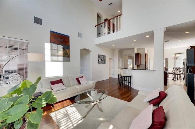 620 Mirabay Blvd, Apollo Beach, FL 33572 - living room featuring wood finished floors, arched walkways, a high ceiling, and decorative columns