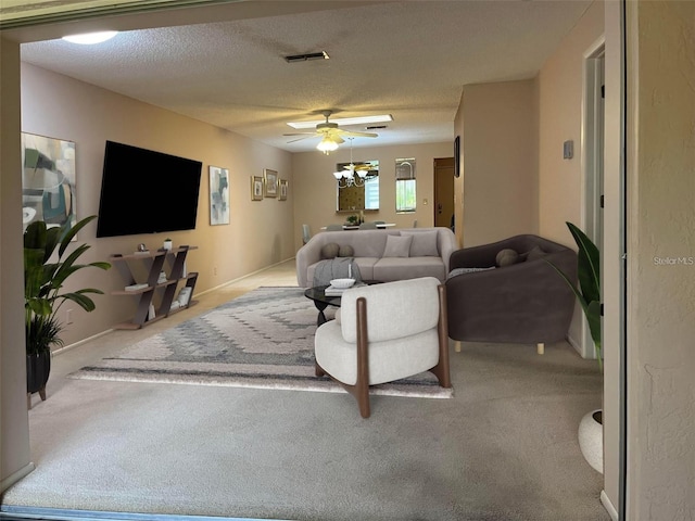 carpeted living room featuring ceiling fan and a textured ceiling