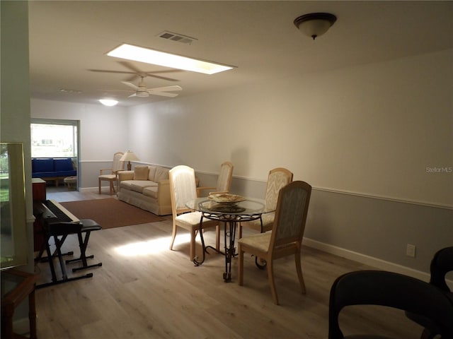 3259 Hilary Cir Unit 1A, Palm Harbor, FL 34684 - dining space with wood finished floors, a ceiling fan, and a skylight