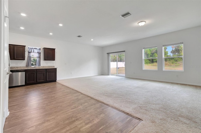 unfurnished living room with carpet floors and sink