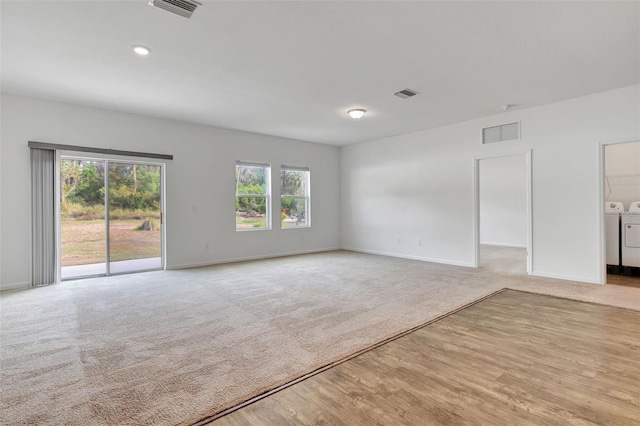 carpeted spare room featuring washing machine and clothes dryer