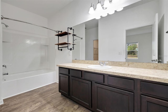 bathroom with bathtub / shower combination, vanity, hardwood / wood-style flooring, and a chandelier