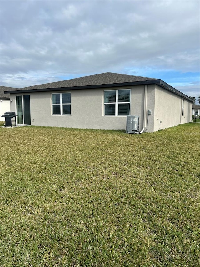 view of side of home featuring a yard and central AC