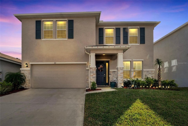 view of front facade with a garage and a yard