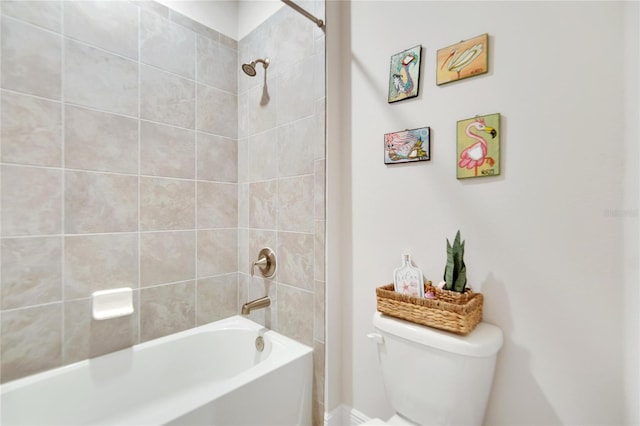 bathroom featuring toilet and tiled shower / bath