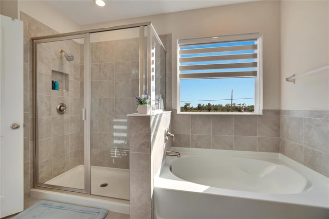 bathroom featuring separate shower and tub