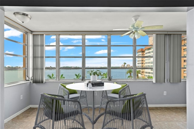 sunroom with ceiling fan, a water view, and a healthy amount of sunlight