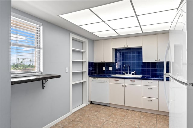 kitchen with tasteful backsplash, white cabinetry, sink, and white appliances