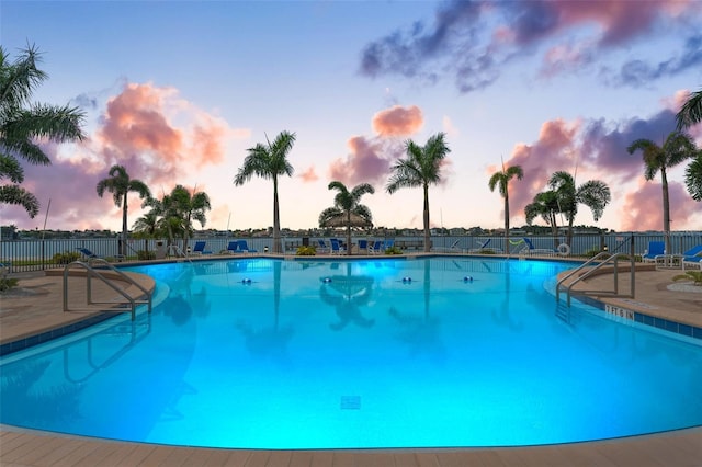 pool at dusk featuring a patio area