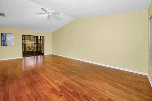 spare room with a textured ceiling, hardwood / wood-style flooring, vaulted ceiling, and ceiling fan