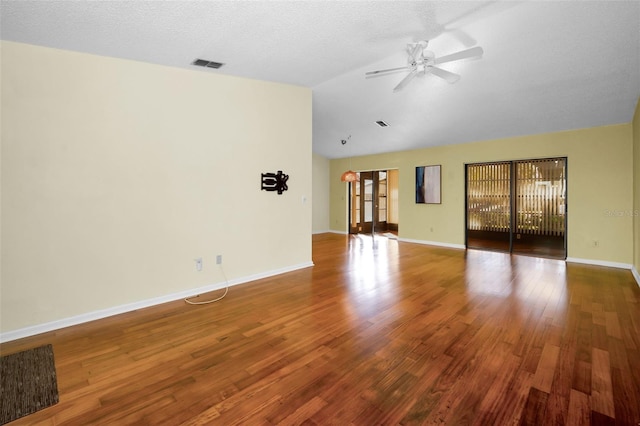 unfurnished living room featuring ceiling fan, wood-type flooring, lofted ceiling, and a textured ceiling