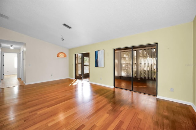 unfurnished room with hardwood / wood-style floors and a textured ceiling