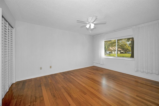 unfurnished bedroom featuring ceiling fan, a textured ceiling, and hardwood / wood-style flooring