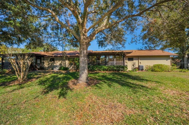 rear view of house featuring a yard and central AC