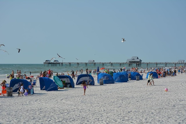 view of property's community with a water view and a view of the beach