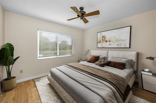 bedroom with ceiling fan and hardwood / wood-style flooring