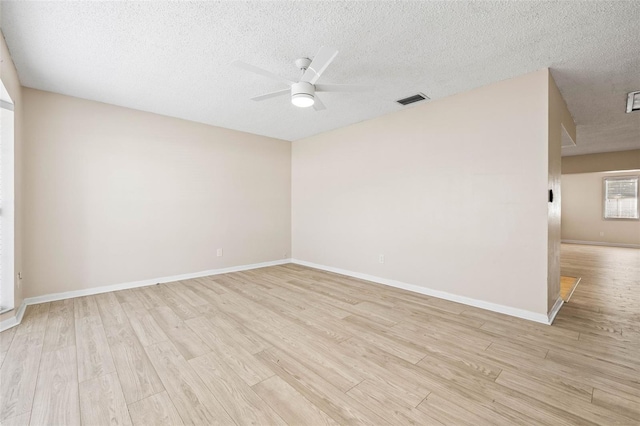 empty room with ceiling fan, light hardwood / wood-style floors, and a textured ceiling