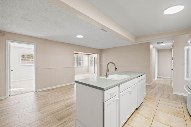 kitchen featuring a kitchen island with sink, sink, light hardwood / wood-style flooring, dishwasher, and white cabinetry