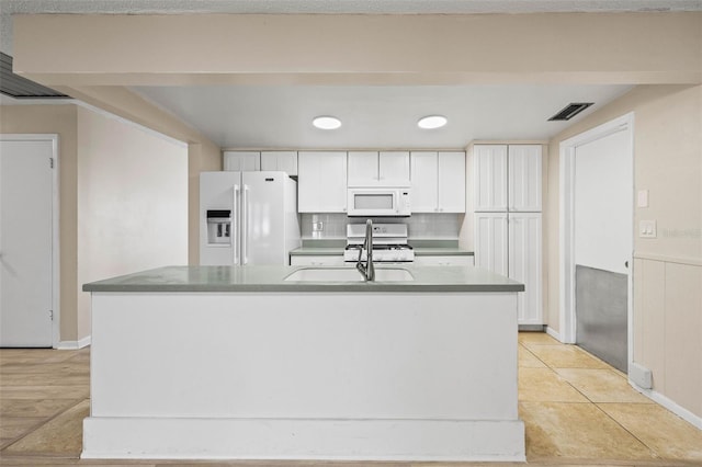 kitchen featuring white cabinets, light tile patterned floors, white appliances, and sink