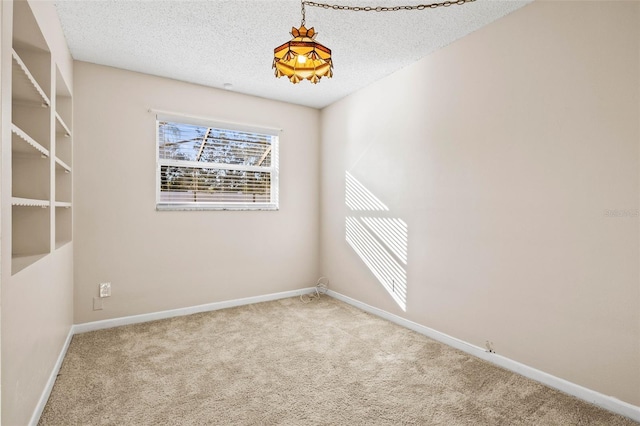 empty room with light colored carpet and a textured ceiling