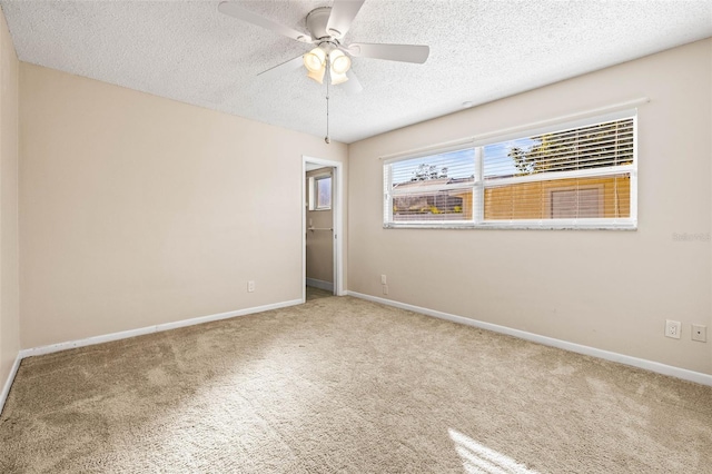 empty room with carpet, ceiling fan, and a textured ceiling