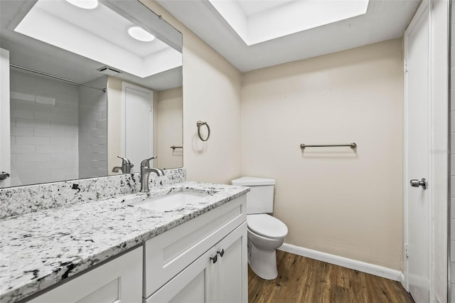 bathroom featuring walk in shower, vanity, wood-type flooring, and toilet