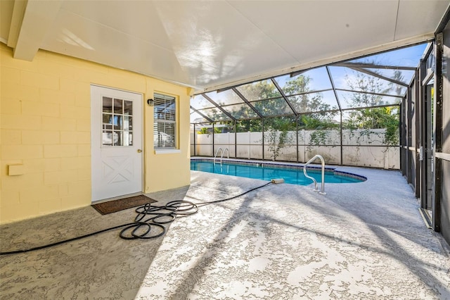 view of pool featuring glass enclosure and a patio area