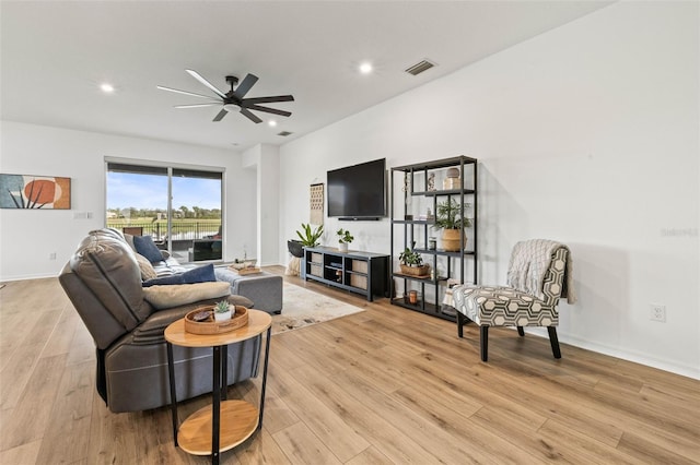 living room with light wood-type flooring and ceiling fan