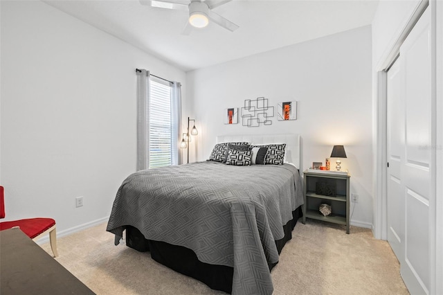 bedroom featuring ceiling fan, a closet, and light colored carpet