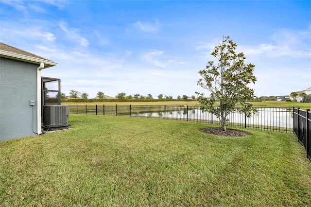 view of yard featuring central AC and a water view