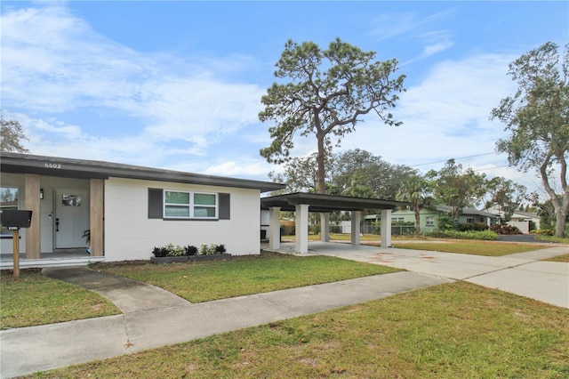 view of front of property with a front lawn and a carport