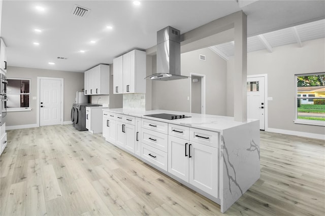 kitchen featuring white cabinets, wall chimney exhaust hood, black electric stovetop, and light stone countertops