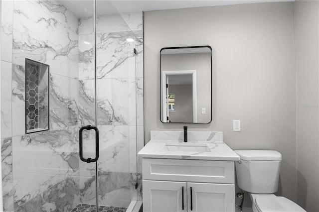 bathroom featuring vanity, toilet, and a shower with shower door