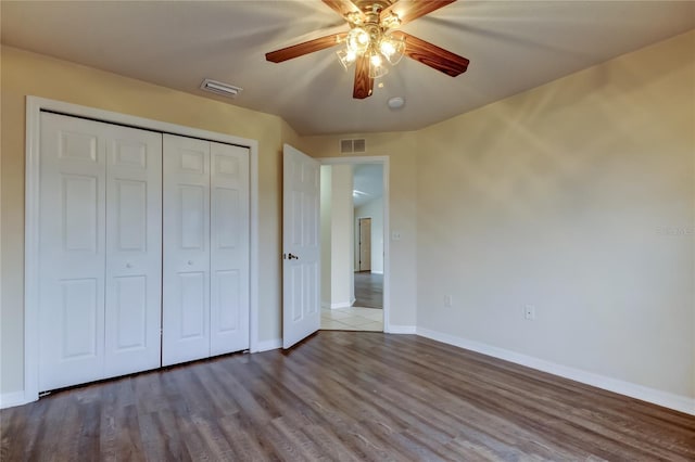 unfurnished bedroom featuring ceiling fan, light wood-type flooring, and a closet