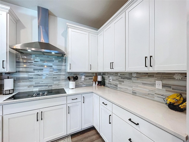 kitchen featuring white cabinets, black electric stovetop, backsplash, and wall chimney exhaust hood