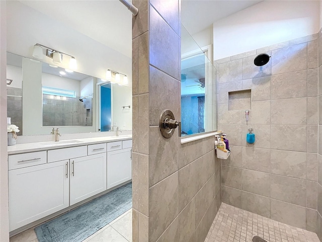 bathroom featuring a tile shower, vanity, and tile patterned floors