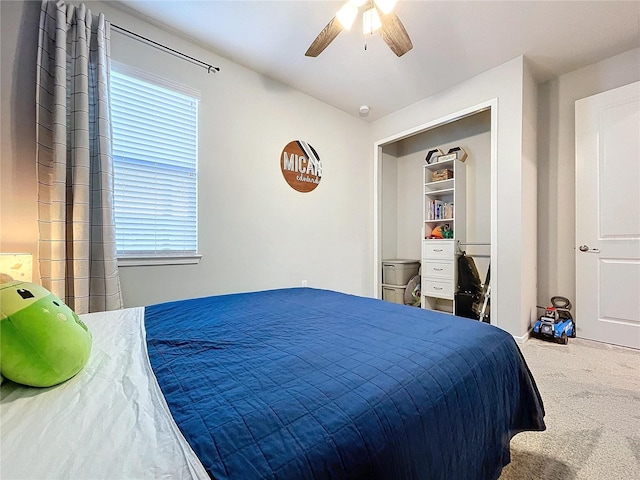 carpeted bedroom with ceiling fan and a closet