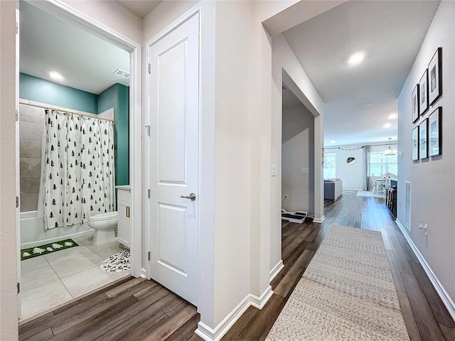 hallway with hardwood / wood-style flooring